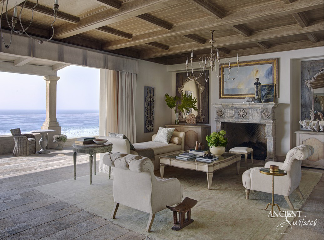 Ancient Surfaces pale reclaimed limestone fireplace mantel in a coffered living room facing the sea