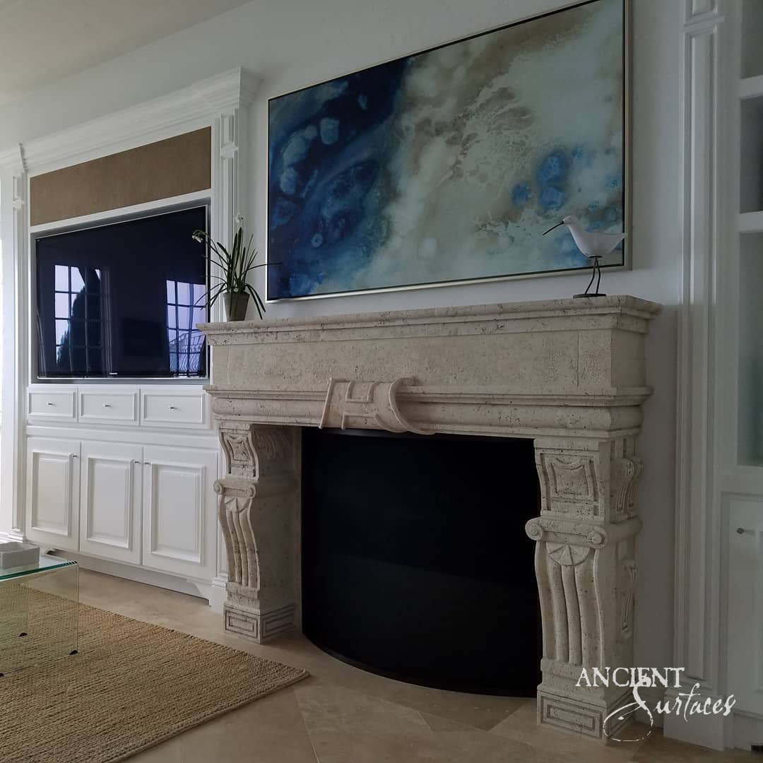 Ancient Surfaces reclaimed limestone fireplace mantel with a scrolled ribbon frieze and fluted pilaster jambs